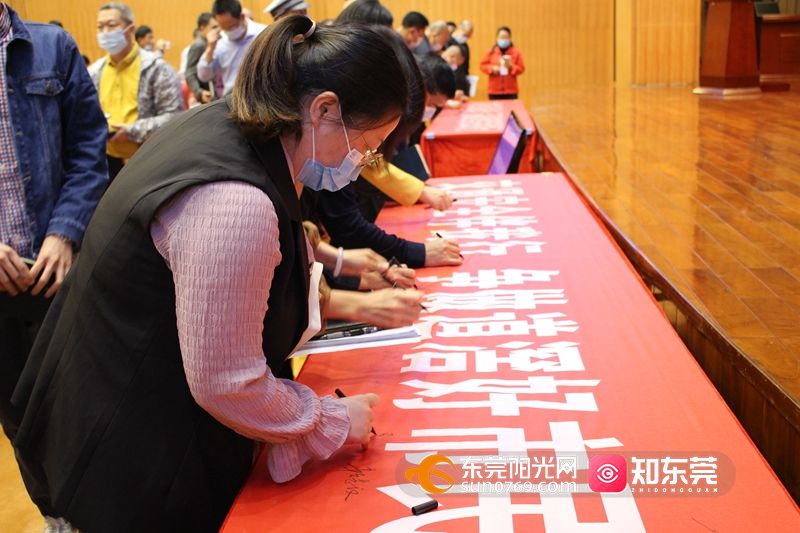 启动仪式上,现场参与者在交通安全标语横幅上进行了签名.