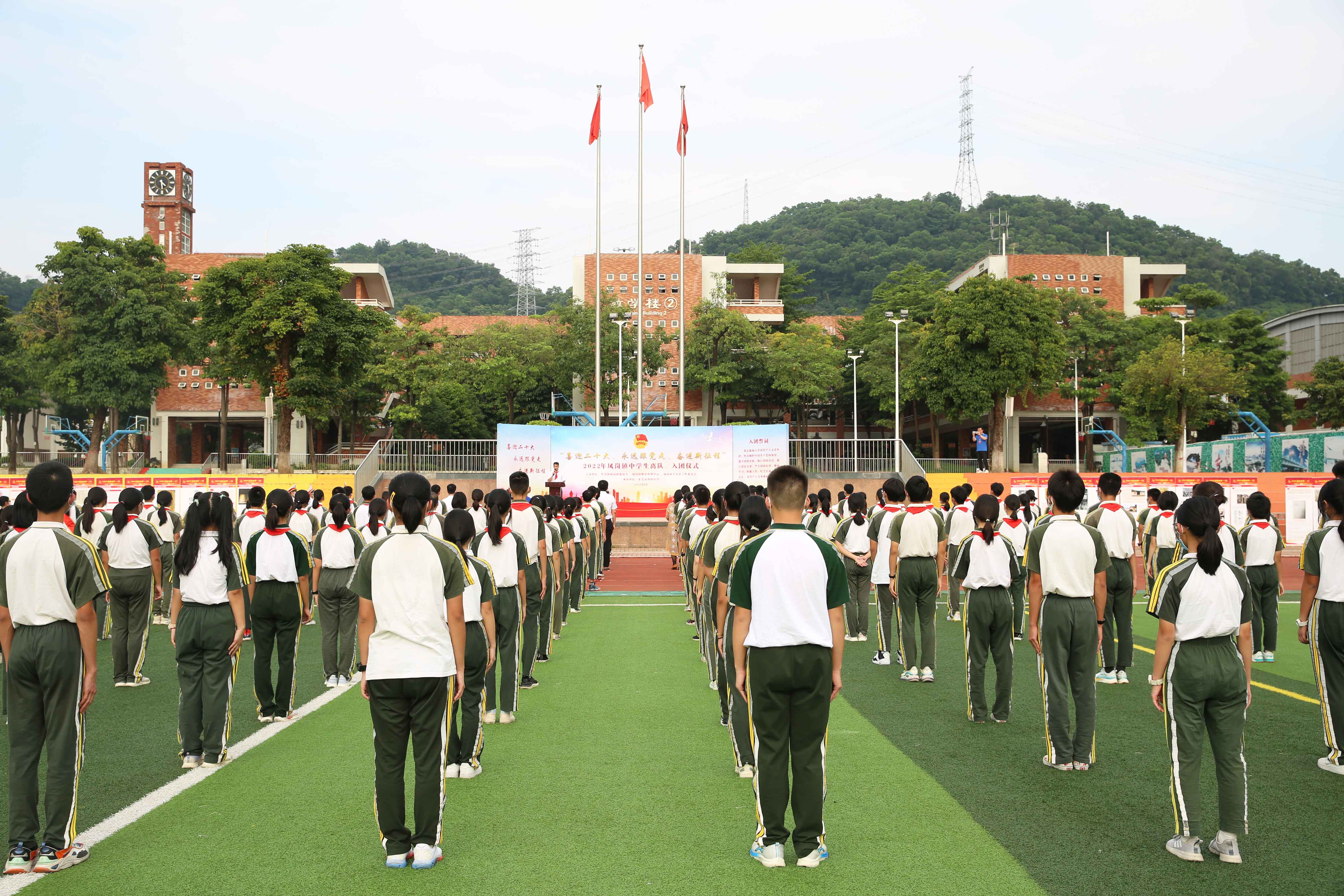 在凤岗华侨中学操场,99名学生在进行了离队仪式和入团宣誓后,佩戴上了